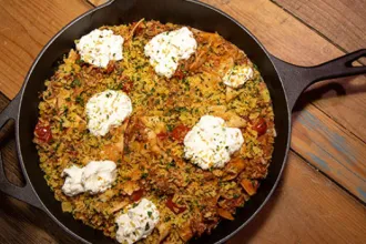 Pan of skillet Lasagna on a wood plank surface.