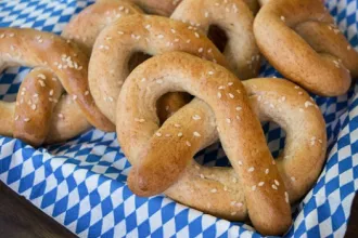 Several soft pretzel on a checkered cloth.