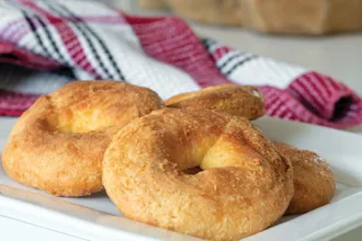 Serving plate of homemade bagels next to a cloth.