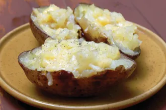 Stoneware plate with 3 stuffed potato halves.