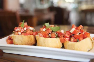Tomato Basil Bruschetta - USDA Rectangular plate with three portions of tomato basil bruschetta.