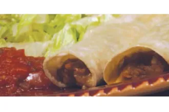 Bean Enchiladas - USDA Extreme closeup of the ends of two bean enchiladas on a plate next to salsa and lettuce.