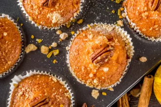 Overhead closeup of a plate of cooked cinnamon sugared pumpkin pecan muffins