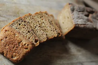 Overhead view of a partially sliced loaf of mixed grain bread.